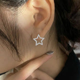 Close-up of star hoop earrings in 925 sterling silver with pave cubic zirconia worn on ear